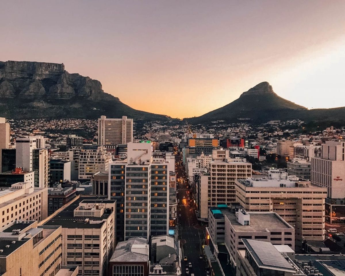 Cape Town city skyline at sunset with Table Mountain and Lions Head in golden light